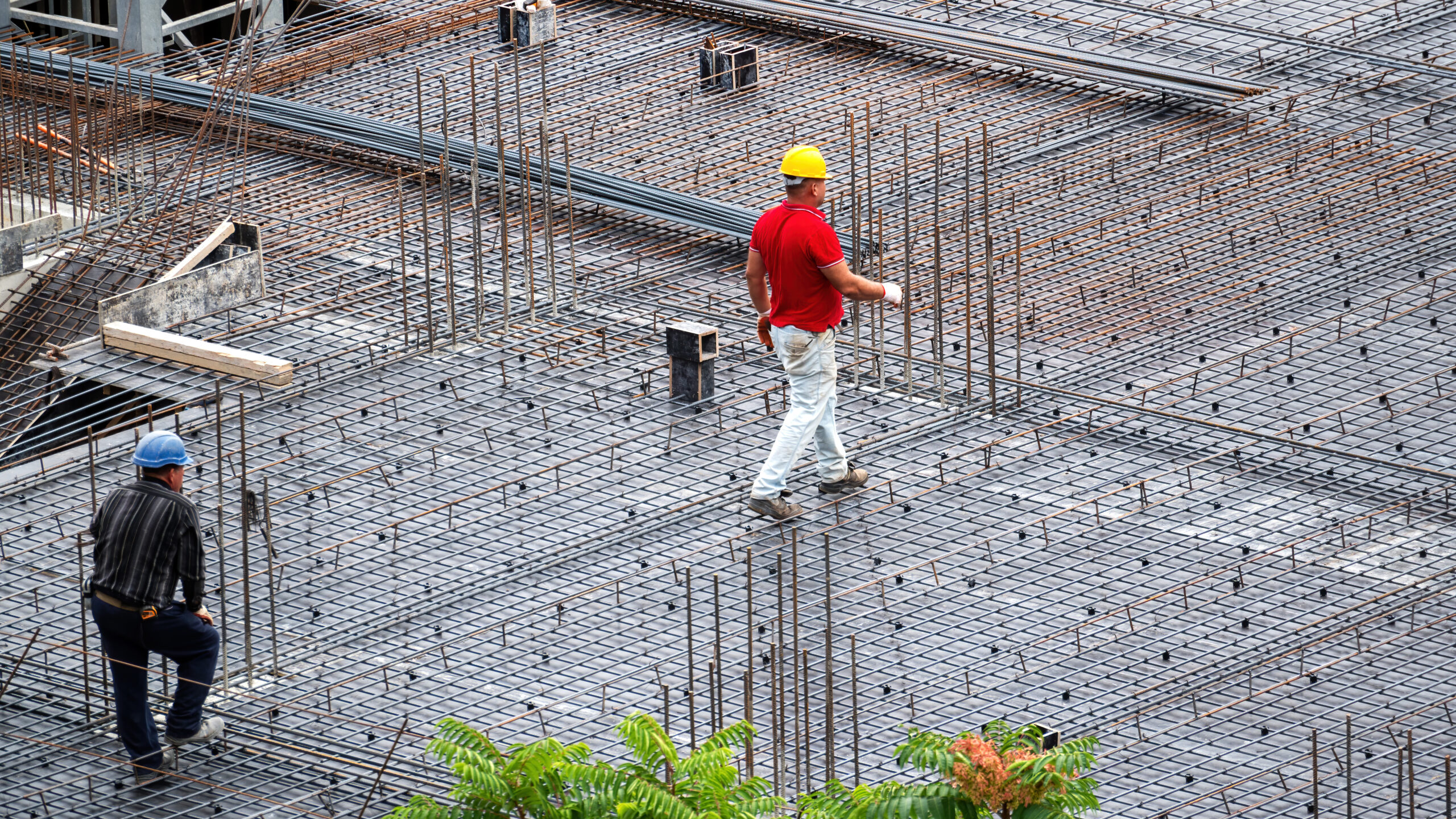 Construction building workers working at the site in a cloudy day